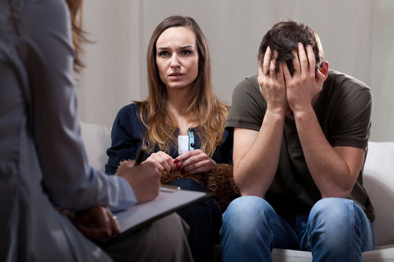 Young unhappy couple at odds on therapy visit